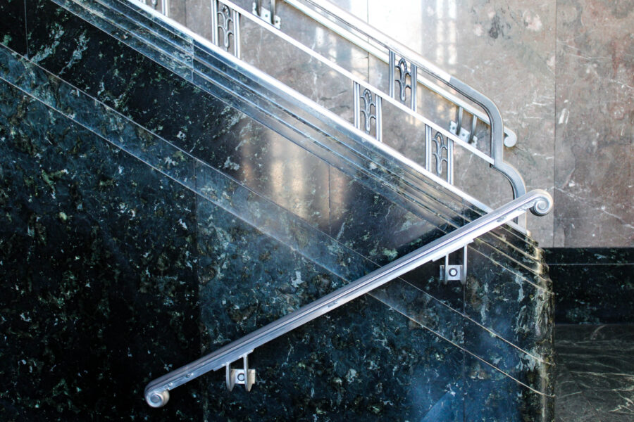 Silver railing on ascending marble staircase