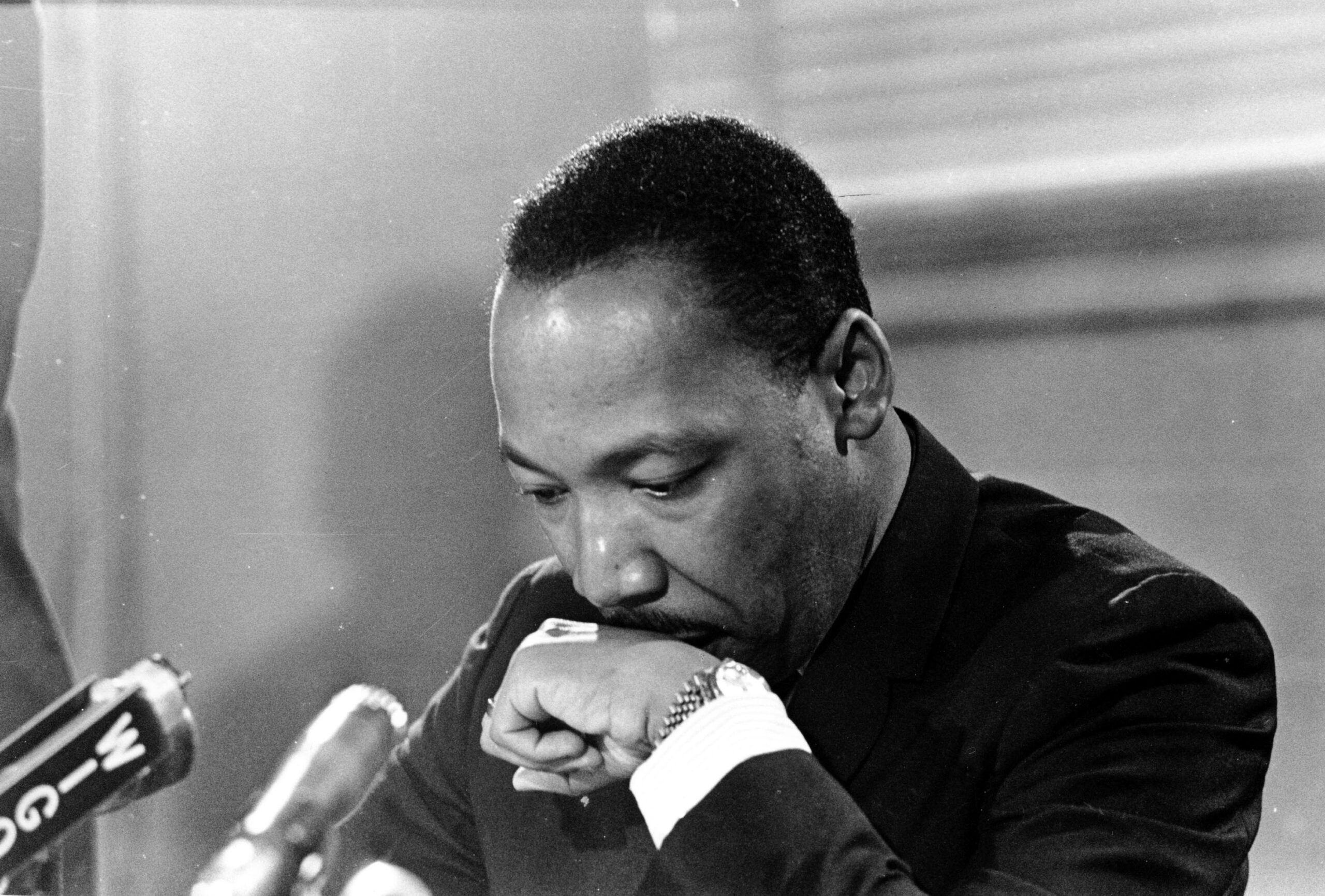 Dr. Martin Luther King Jr appears in deep thought at a press conference.