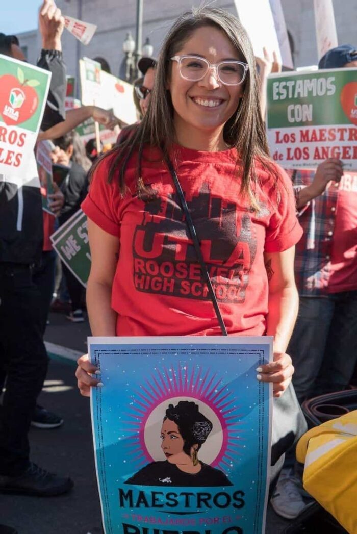 Roxanna Duena at a protest holding a poster