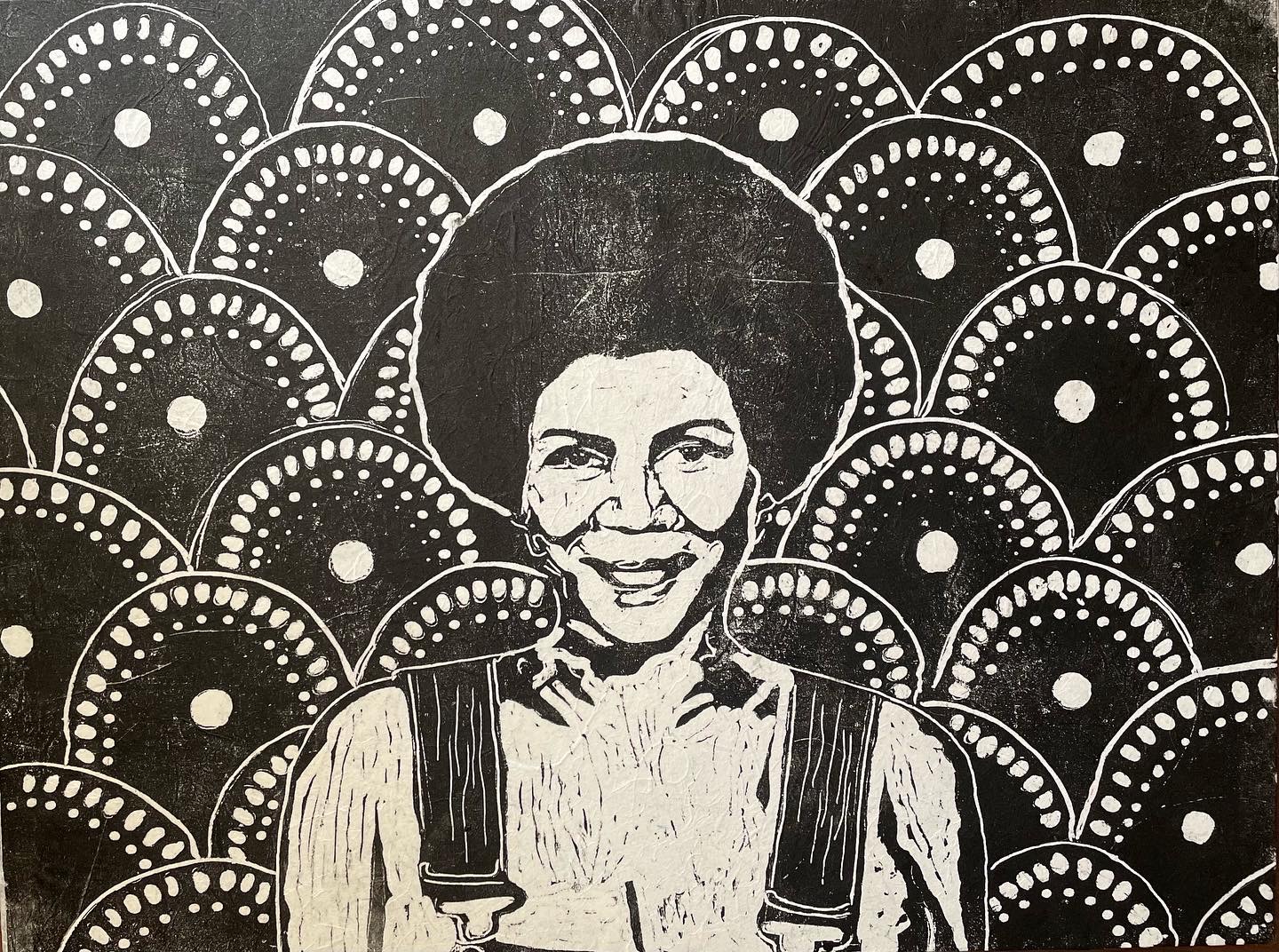 A black and white print shows Minnie Riperton wearing an afro and overalls with circular mandala shapes surrounding her in the background