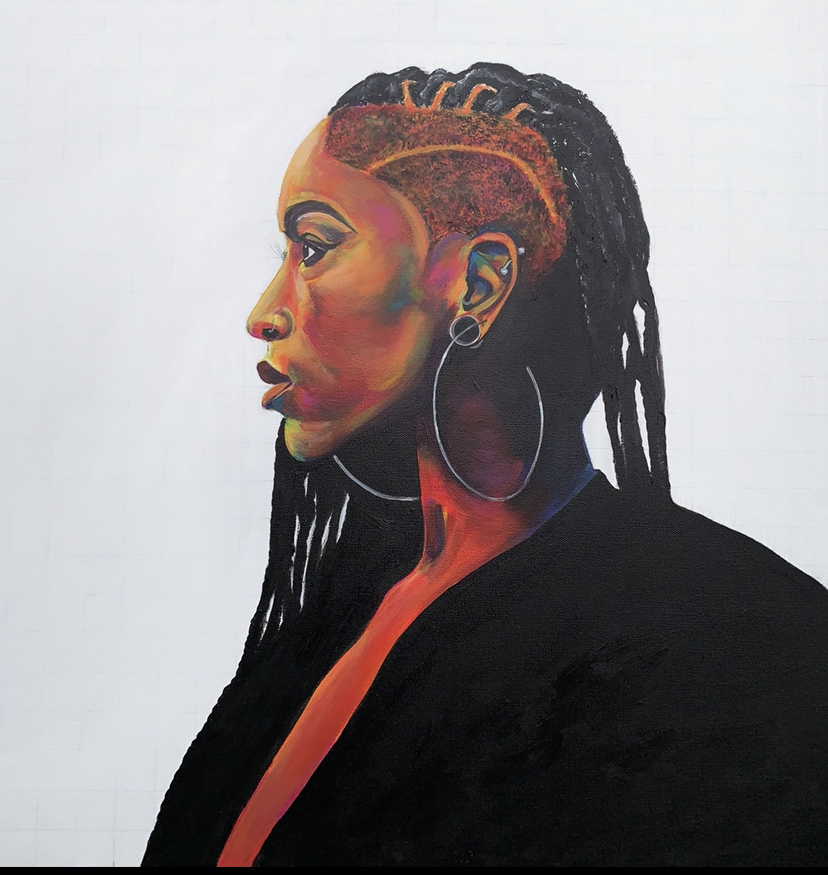 A side profile of a black woman reveals her half head-shaven and half locs hairstyle as she’s wearing gauges and large hoop earrings