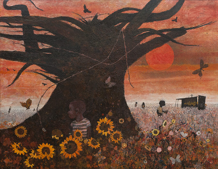 African American boy sitting in front of a large tree with sunflowers blooming all around him.