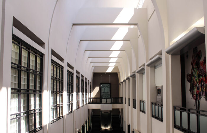 Open room with tall ceilings surrounded by windows.