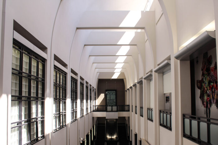 Open room with tall ceilings surrounded by windows.