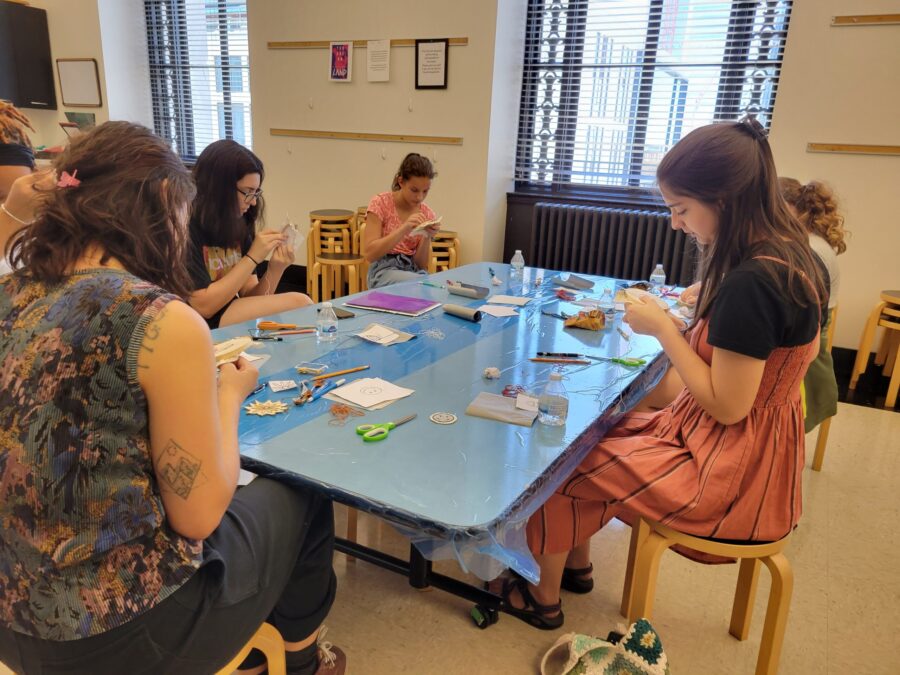 A group of teens work on an art project in an art studio.