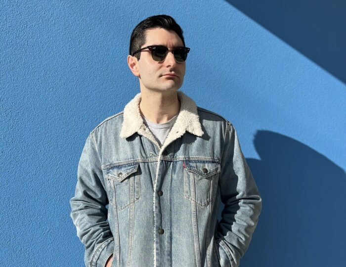 Photo of Adam Paul in a jean jacket and sunglasses.