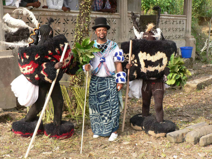 Two raffia Efik Ekpe masquerades with Chief Ekpenyong Bassey Nsa.