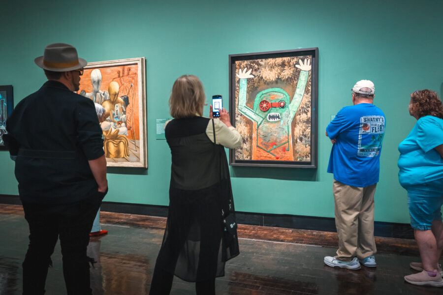 People walking through a gallery with Surrealism paintings