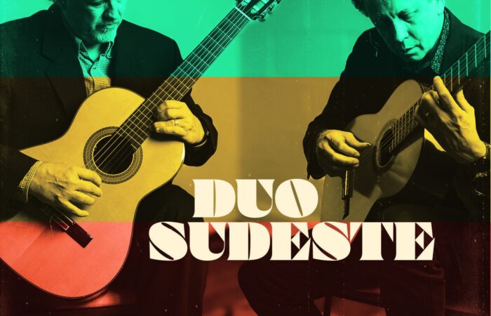 The two men in Duo Sudeste play guitars with a green, yellow, and red striped overlay.