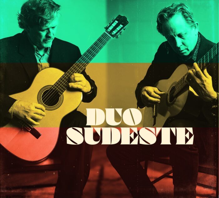 The two men in Duo Sudeste play guitars with a green, yellow, and red striped overlay.