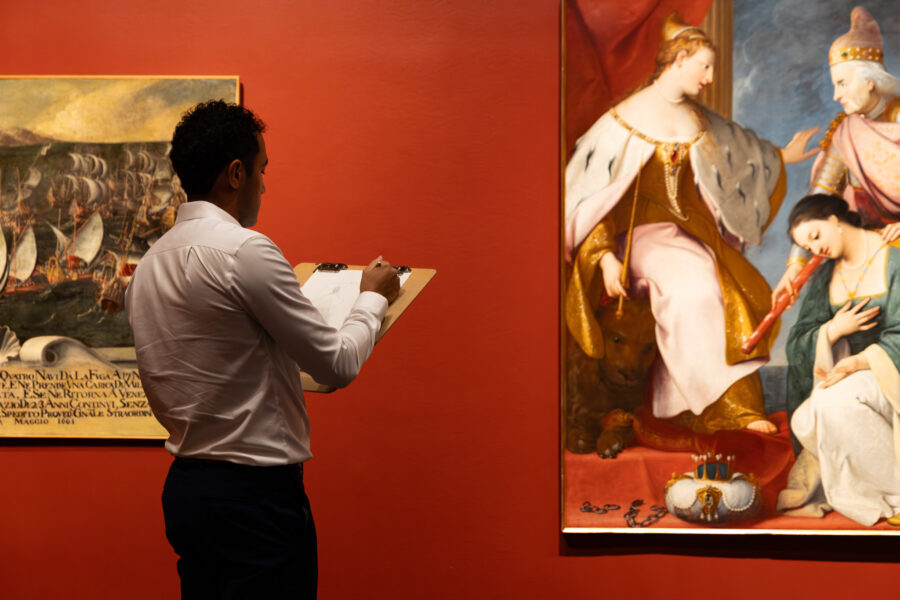 Man sketches painting in an art gallery