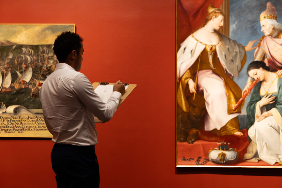 Man sketches painting in an art gallery