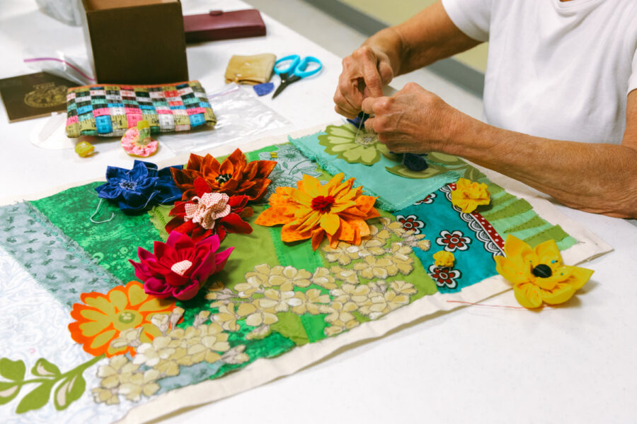 close up of hands working on a quilted square