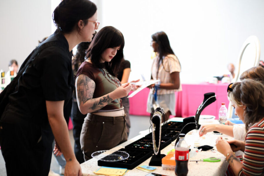 Teens stand around a jewelry vendor