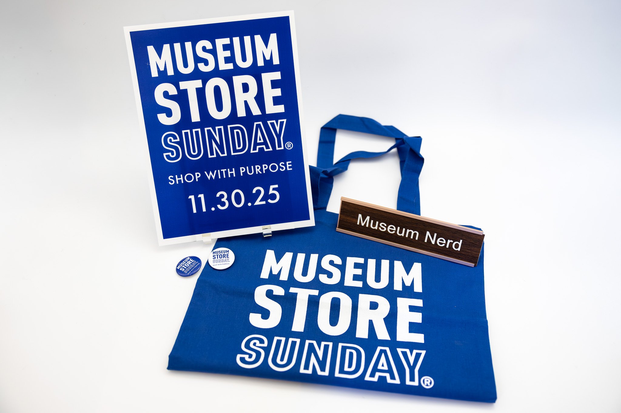 Museum Store Sunday sign and tote and a desk plate that reads 