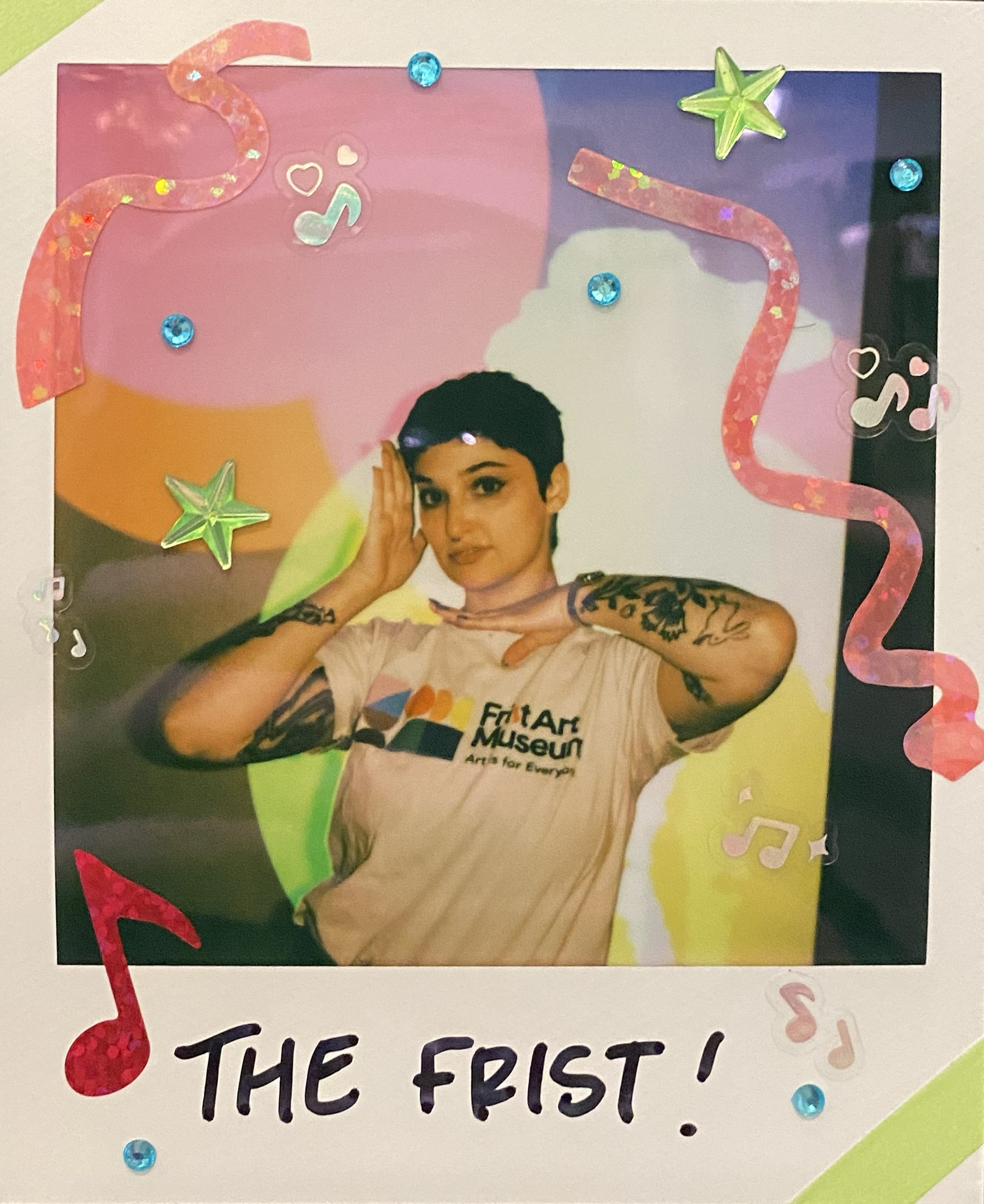 Polaroid picture of a young lady posing with her hands framing her face. The print out is decorated with stars and confetti like shapes