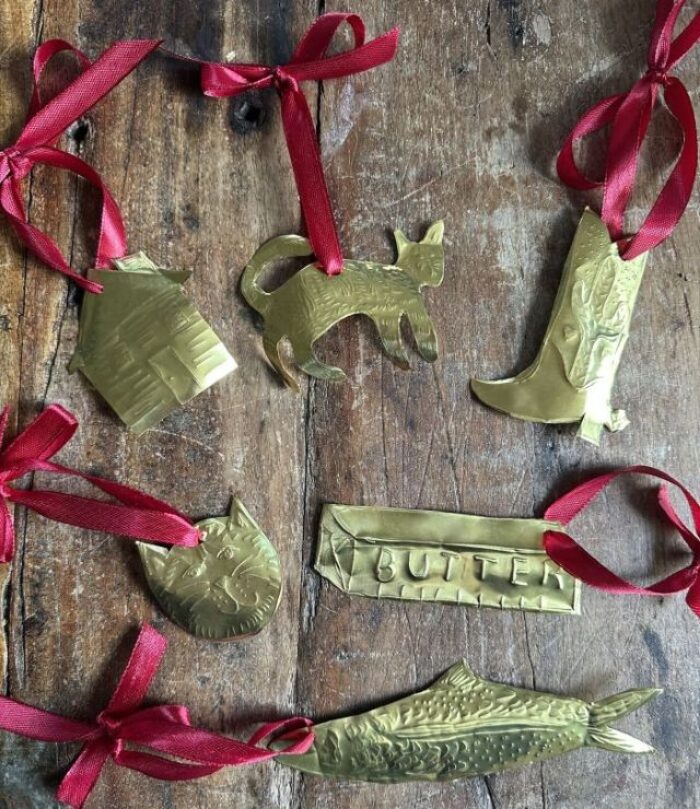 a selection of brass ornaments with red ribbon hangers