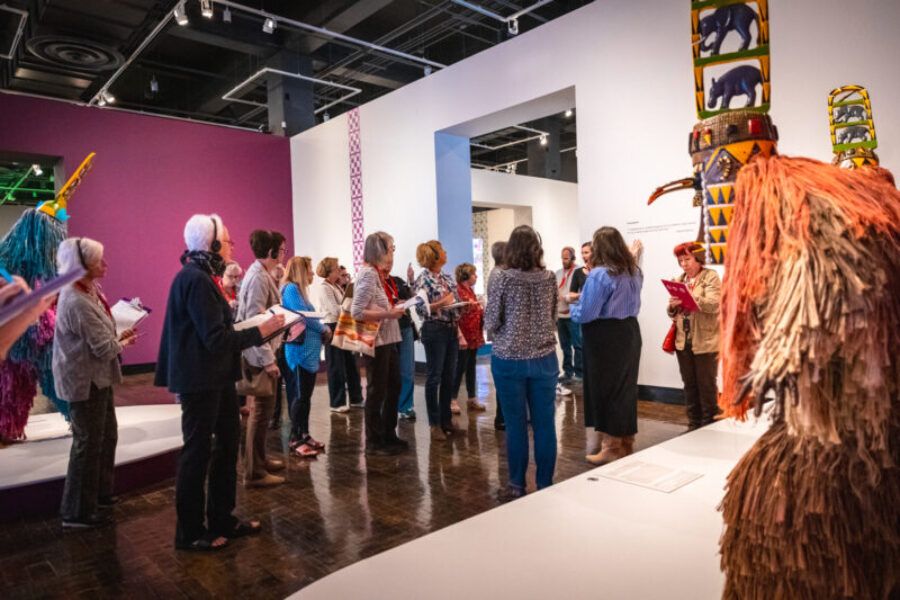 Group of people look at African Masquerades on a tour.