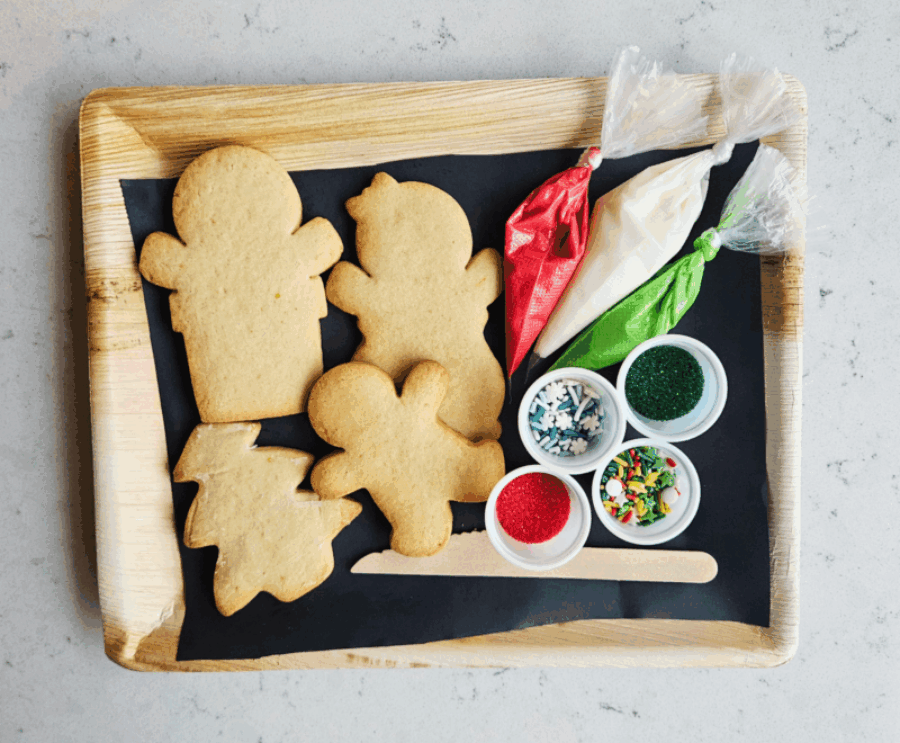 A tray of Christmas cookies with icing and sprinkles.