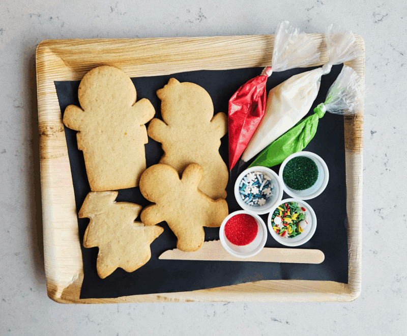 A tray of Christmas cookies with icing and sprinkles.