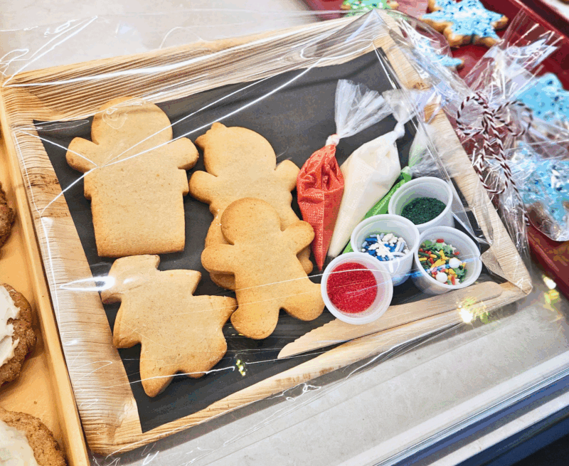 Cookies, icing, and sprinkles gift wrapped on a tray.