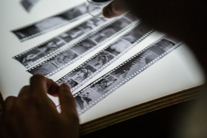 A person's hands are holding film strips.