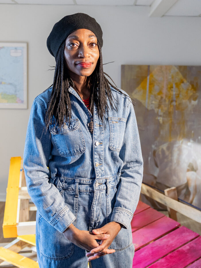 Headshot of artist Lakesha Calvin with her sculpture in the background. 