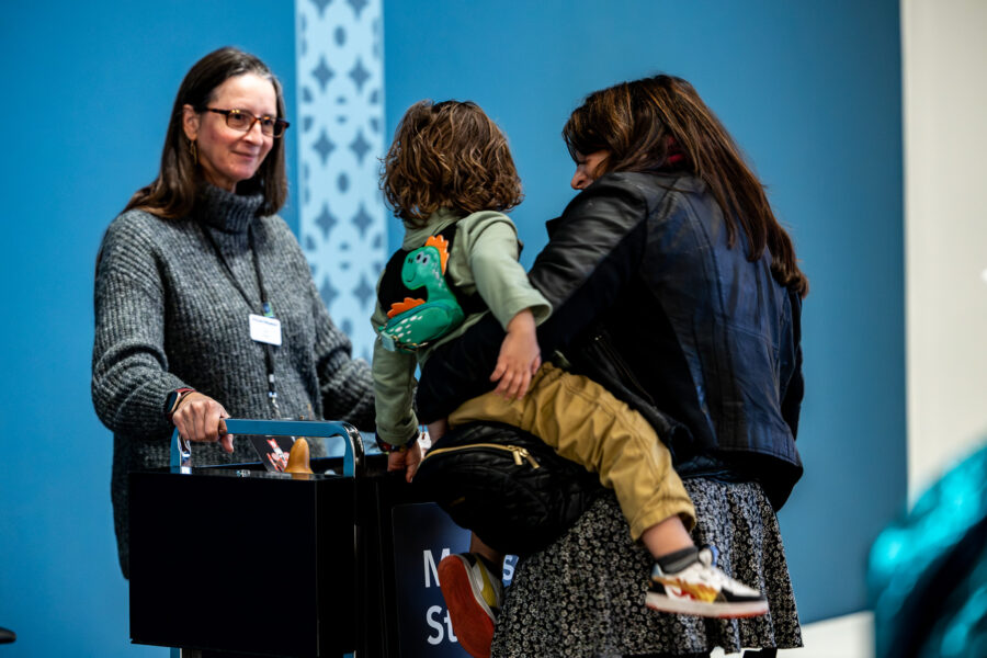 A mom and son look at a sensory stand in an art museum.