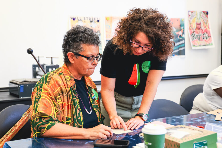 Two women work together in a print making class.