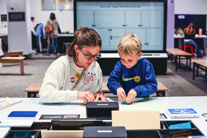 A woman does a craft with a little boy.
