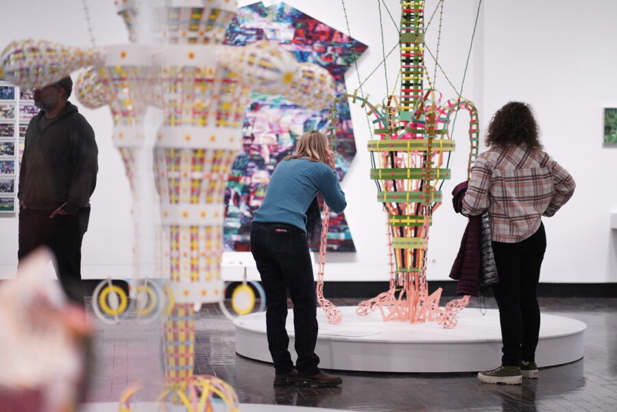 Two women looking closely at a colorful abstract scultpure
