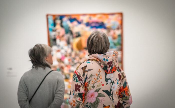 Two women look at a quilt.
