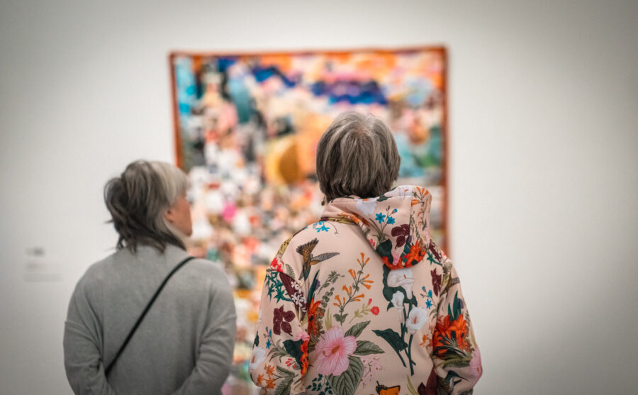 Two women look at a quilt.