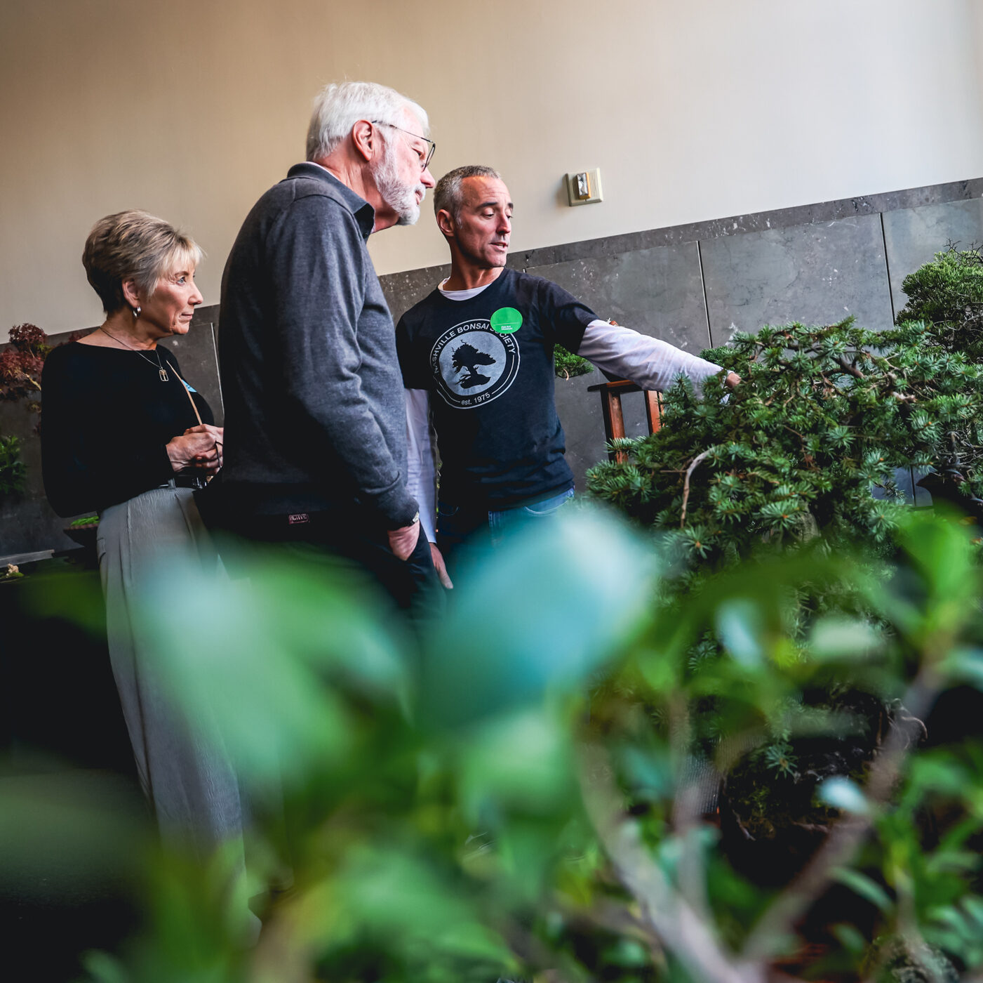 Three people look at plants.