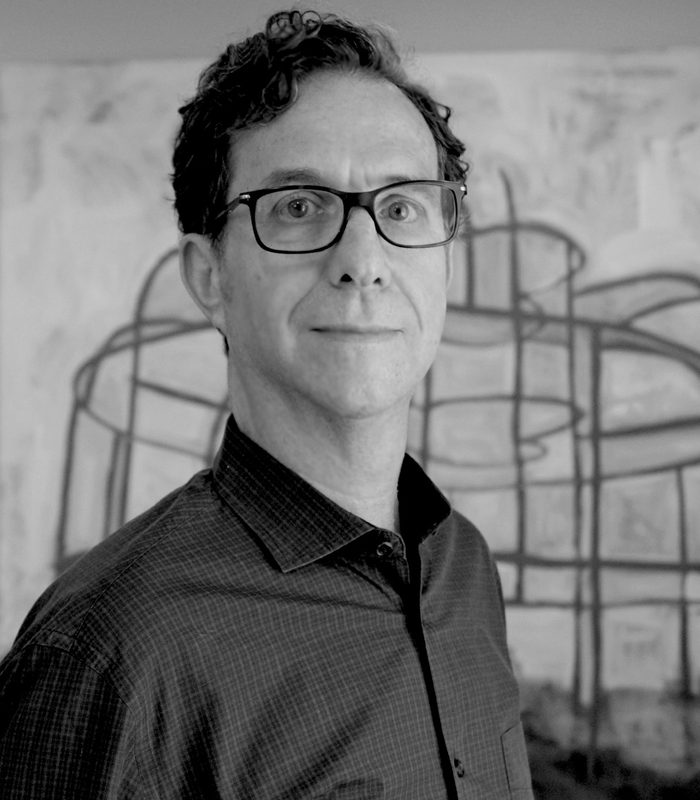 A black and white photo of a man with glasses.