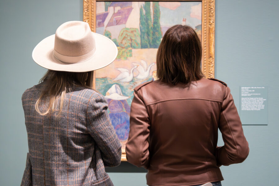 Two people looking at an Impressionist painting.