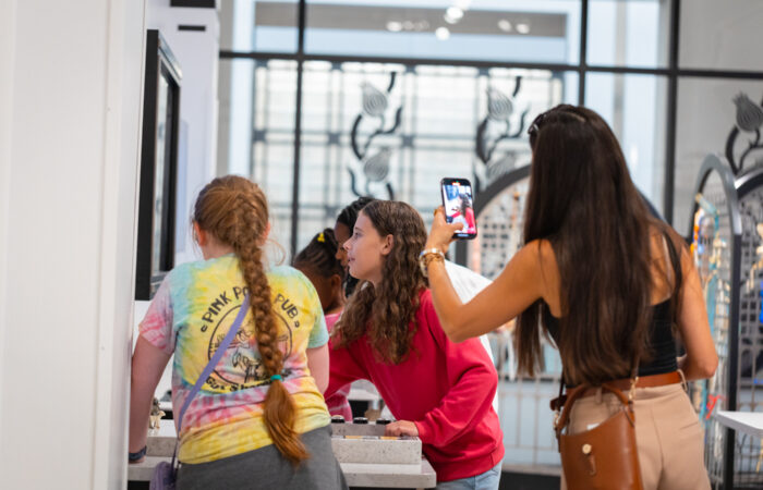 A mom takes a photo of two girls playing at an animation station.