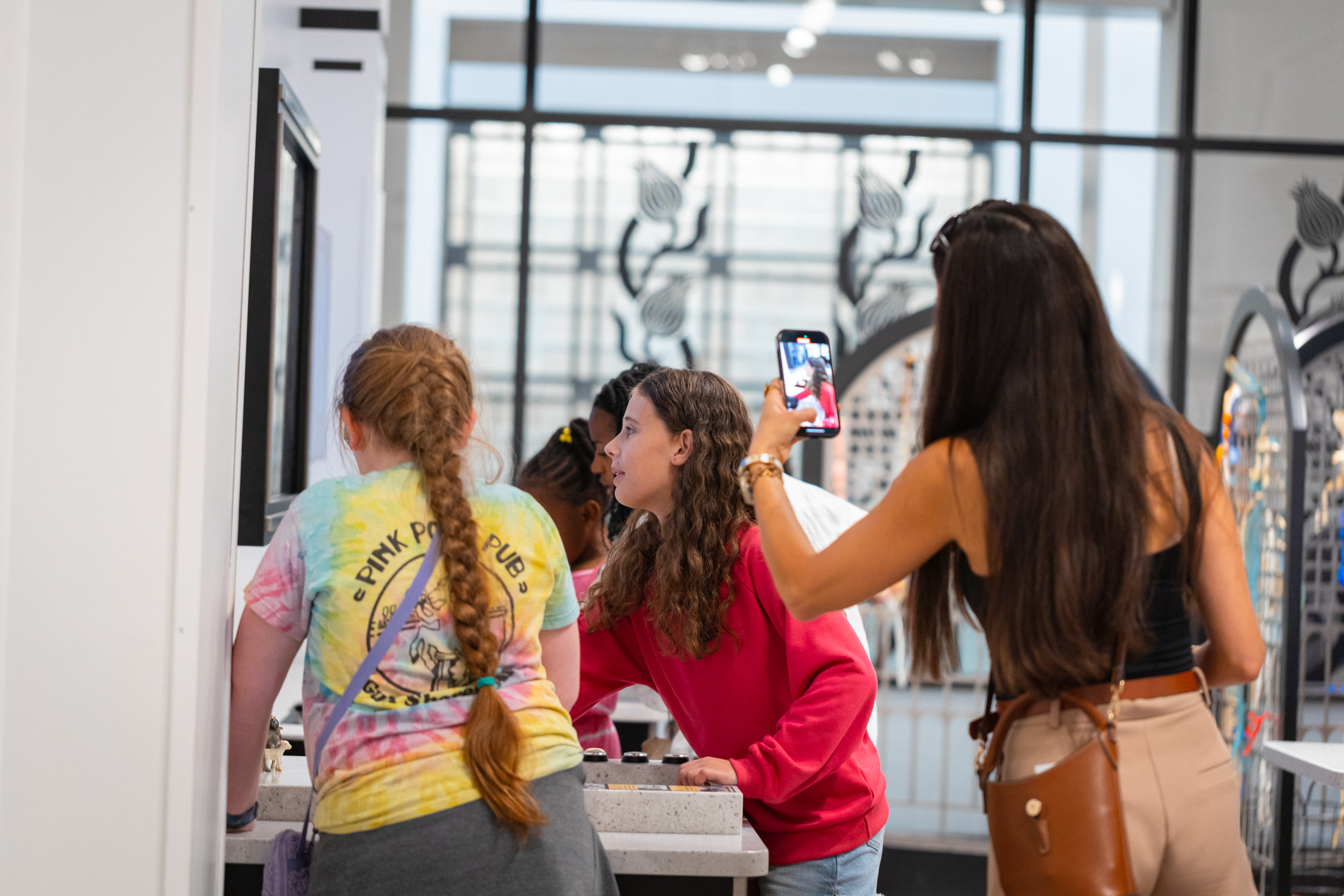 A mom takes a photo of two girls playing at an animation station.