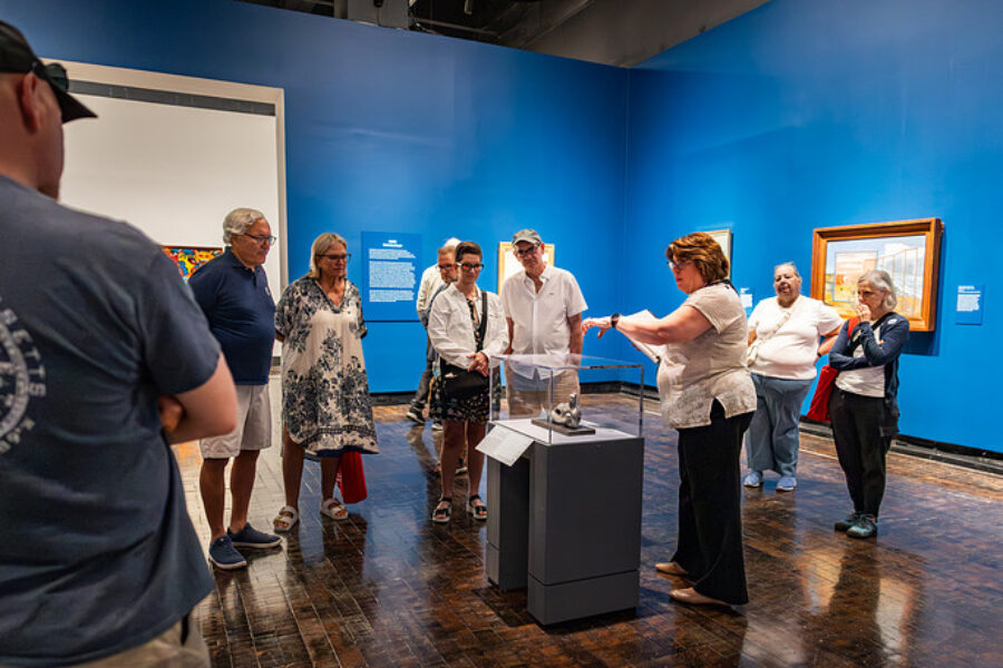 Woman explaining about object in art exhibition.