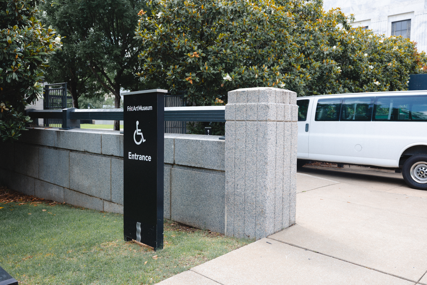 Accessibility sign with a wheelchair next to a sidewalk