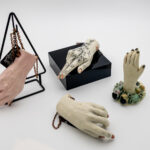 A series of ceramic hands arranged with a white background.