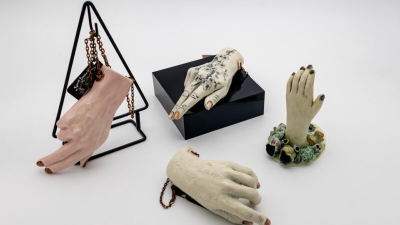 A series of ceramic hands arranged with a white background.