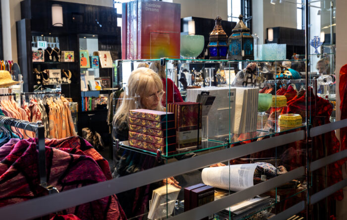 A woman looks at items in an art museum gift shop.
