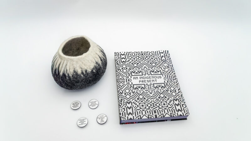 A grouping of buttons, a felt vase, and a book title 