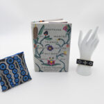 A beaded journal, a patterned pouch, and a beaded bracelet on a white background.