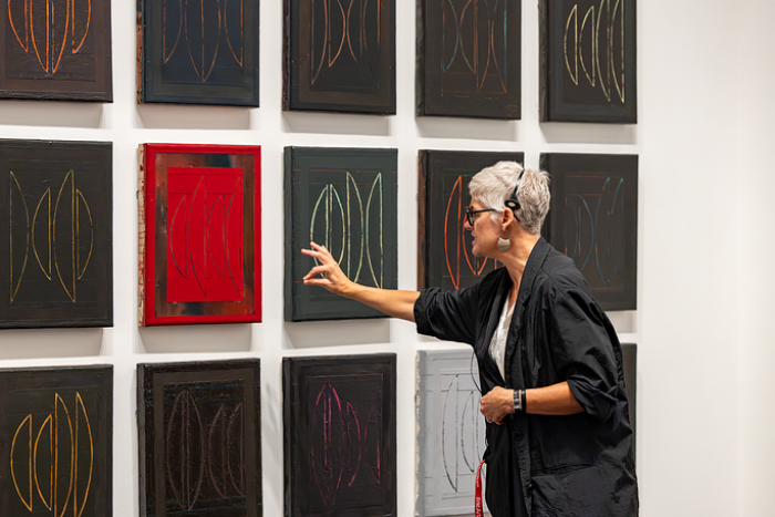 Woman explains about contemporary artwork at an arts museum.