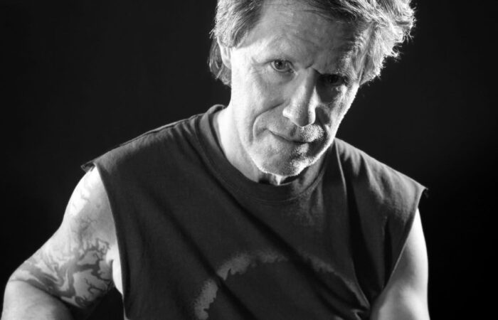 A black and white photo of a man holding a guitar.