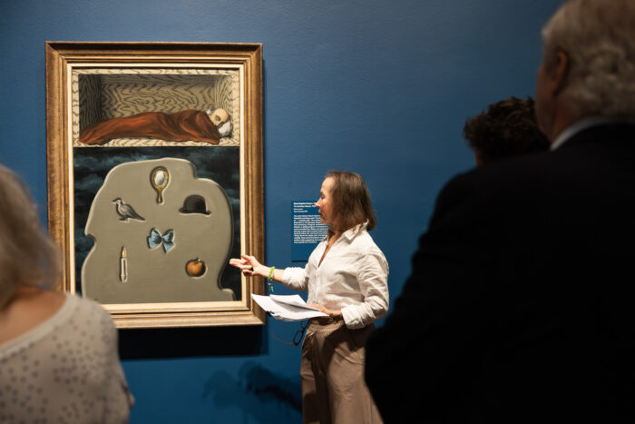 Woman explains about surrealist artwork at an art museum