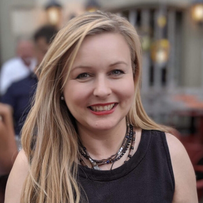 A woman with blonde hair smiles at the camera. 