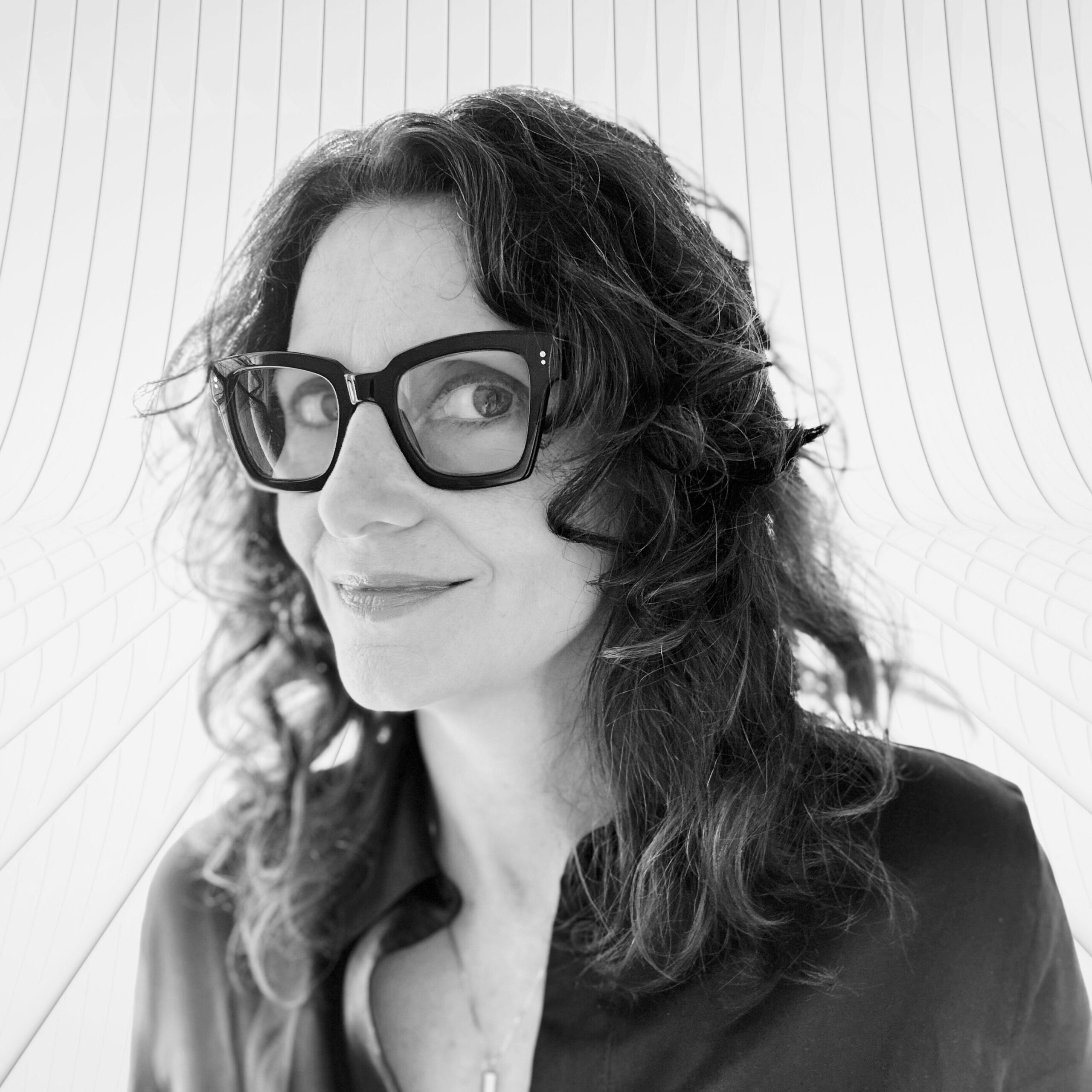 A black and white photo of a woman with large black glasses.